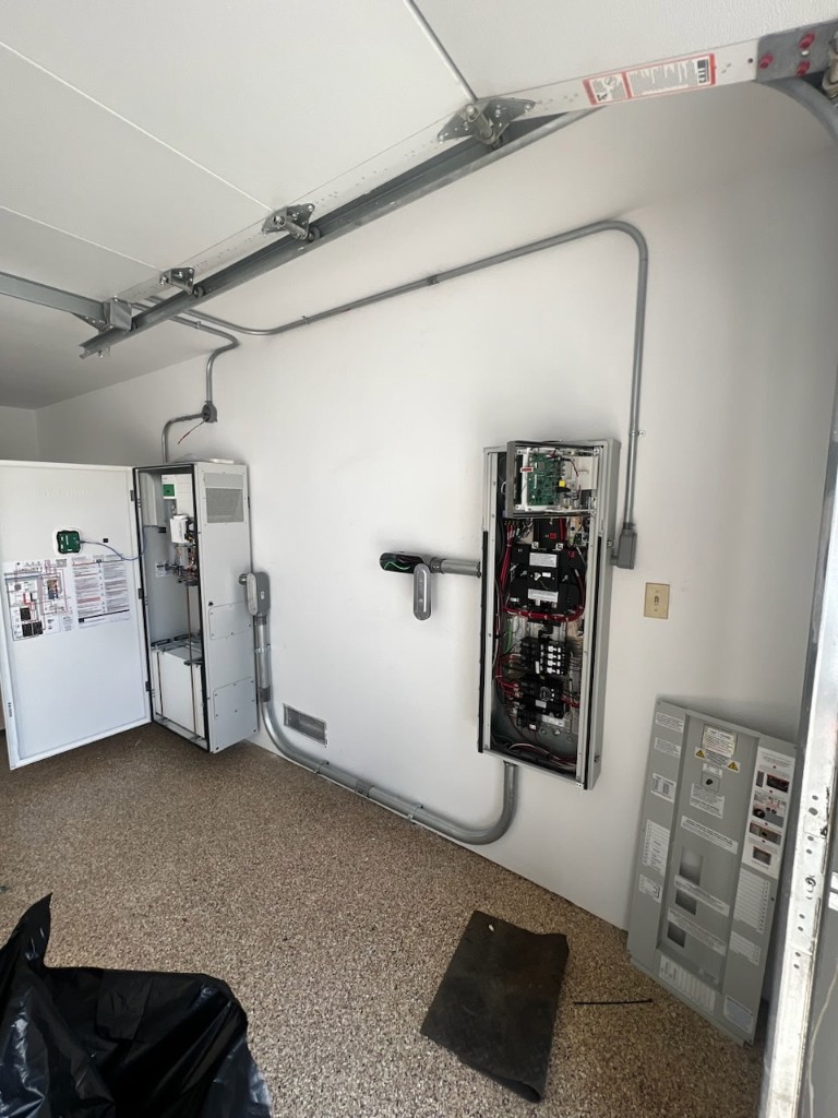 Electrical panels and conduit rough-in for a garage battery installation