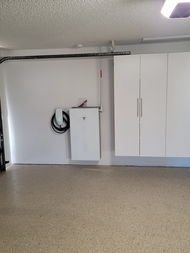 Tesla Powerwall and Wall Connector installed in a residential garage