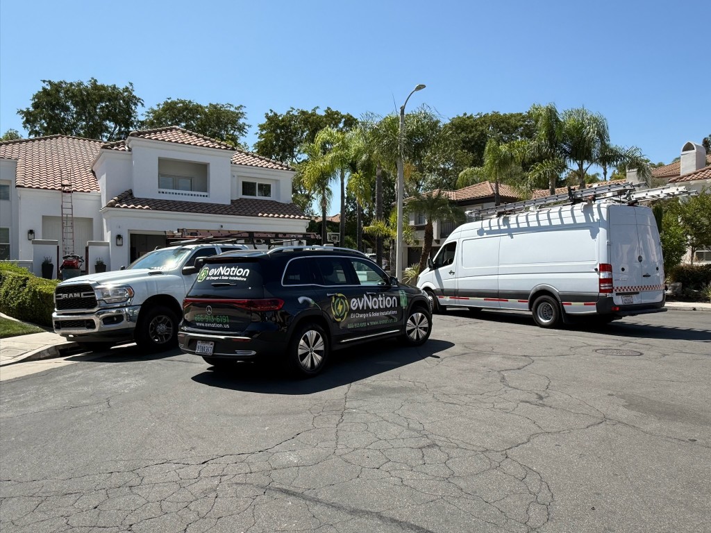 evNation branded SUV, pickup, and service van parked at a residential install job