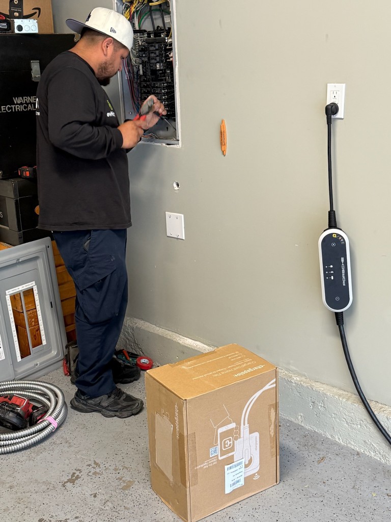 evNation technician wiring a ChargePoint Home Flex install inside a residential garage